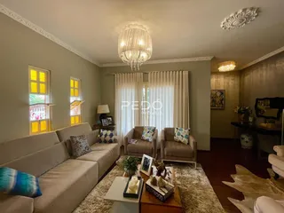 Sala de estar com sofá e cortinas claras em um imóvel no Brasil.