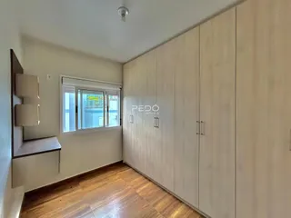 Quarto com armários embutidos e piso de madeira clara.