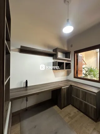 Cozinha com armários de madeira escura e bancada.