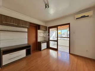 Sala de estar com piso de madeira e portas de vidro que dão acesso ao exterior.