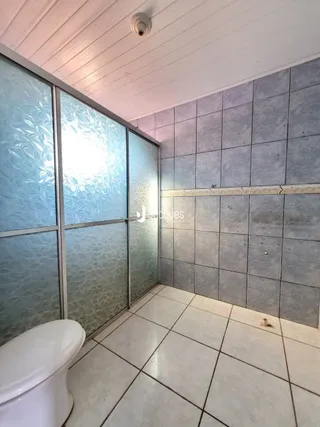 Foto de um banheiro com piso e paredes de azulejo.