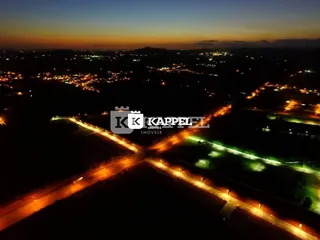 Vista aérea de uma área urbana e campos à noite.