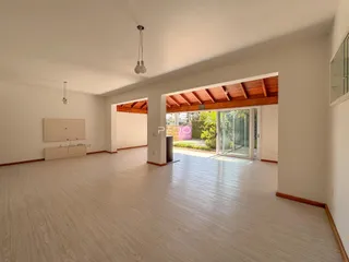 Sala de estar ampla com piso claro e abertura para o exterior.