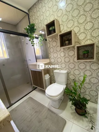 Banheiro com piso de cerâmica e nichos decorativos na parede.