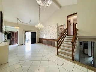 Sala de estar ampla com piso de cerâmica e parede de mármore.