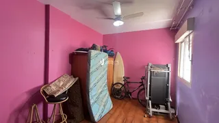 Quarto com paredes rosa e piso de madeira em uma residência.