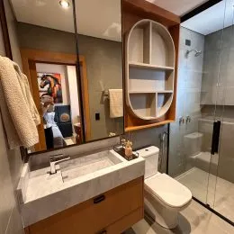 Foto de um banheiro com pia e box de vidro transparente.