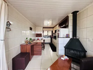 Interior de uma cozinha com piso de cerâmica e paredes brancas.