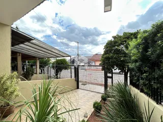 Vista externa do quintal com cerca e vegetação.