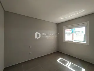 Ambiente interno de uma sala com piso de cerâmica e paredes brancas.