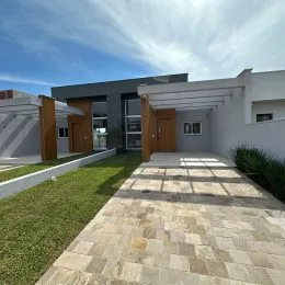 Vista externa de um pátio pavimentado com gramado em uma residência.