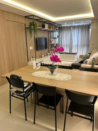 Sala de estar com mesa de madeira e estantes modernas.