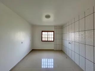 Vista interna de um ambiente com piso de cerâmica e paredes brancas.