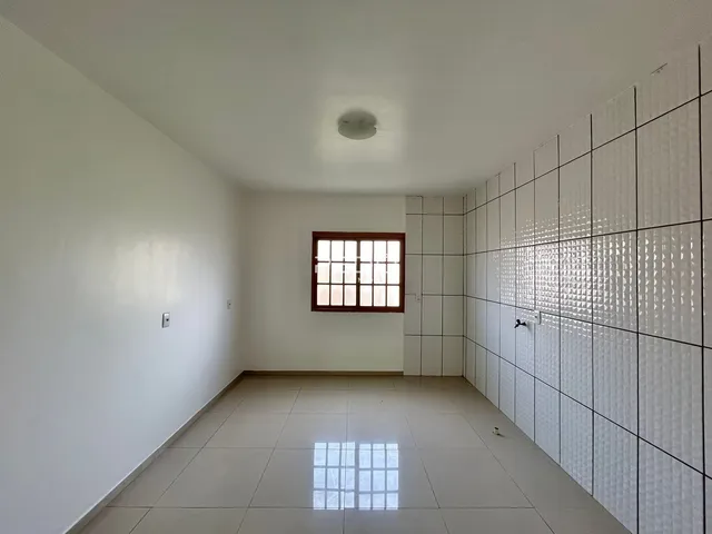 Vista interna de um ambiente com piso de cerâmica e paredes brancas.