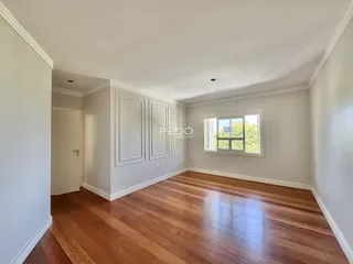 Sala com piso de madeira e janela.