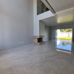 Interior amplo e moderno com piso claro e paredes brancas.