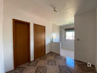 Interior de um corredor com portas de madeira e piso de cerâmica.