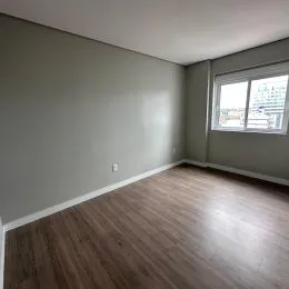 Ambiente interno com piso de madeira e janela visível.