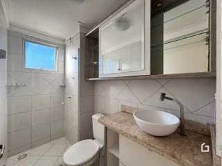 Foto de um banheiro com revestimento de azulejos brancos e bancada de granito.
