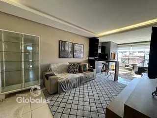 Sala de estar com sofá e painel de vidro na residência.