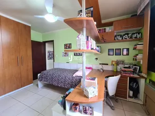 Quarto com armário e cama de madeira em um imóvel no Brasil.