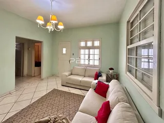Sala de estar com paredes verde-claro e piso de cerâmica.