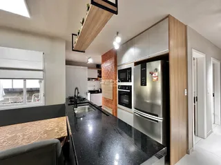 Foto de uma cozinha moderna com armários brancos e bancada escura.