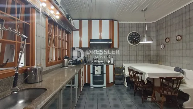 Foto de uma cozinha com armários de madeira e piso de cerâmica.