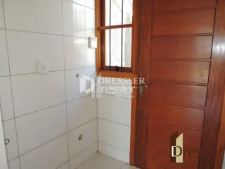 Parede interna com revestimento cerâmico e porta de madeira.