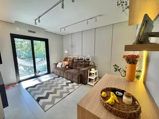 Sala de estar com portas de vidro que dão acesso ao exterior.