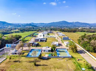 Vista aérea de um complexo residencial com áreas verdes e quadras esportivas.