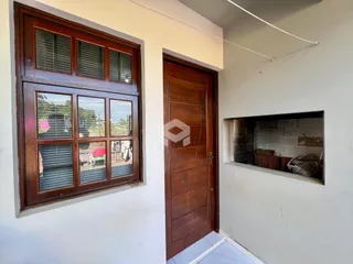 Foto de uma parede interna com janela de madeira e porta de madeira em uma residência.