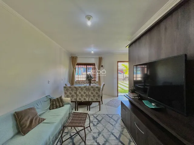 Sala de estar com sofá e televisão em um apartamento no Brasil.