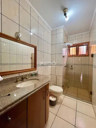 Foto de um banheiro com revestimento de cerâmica e box de vidro.