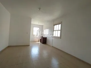 Vista interna de um corredor claro com piso de madeira.