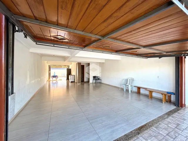 Corredor interno com piso de cerâmica e forro de madeira.