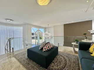 Sala de estar com grandes janelas que dão vista para o exterior.