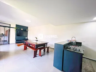Ambiente amplo com mesa de jantar e ilha de cozinha em um imóvel.