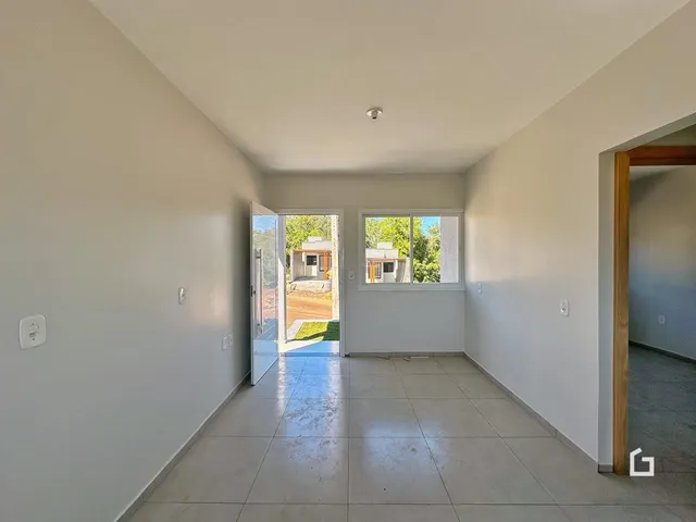 Hall de entrada com piso de cerâmica e parede branca.