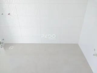Vista interna de um cômodo com paredes brancas e piso claro.