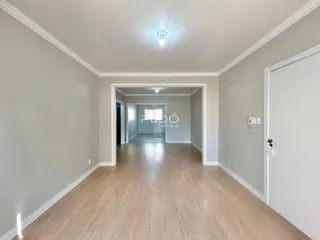 Hall de entrada com piso de madeira clara.