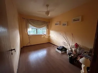 Sala de estar com piso de madeira e janela.