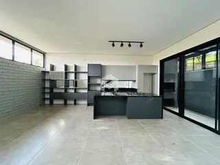 Vista da cozinha moderna com piso de cerâmica e grandes janelas.