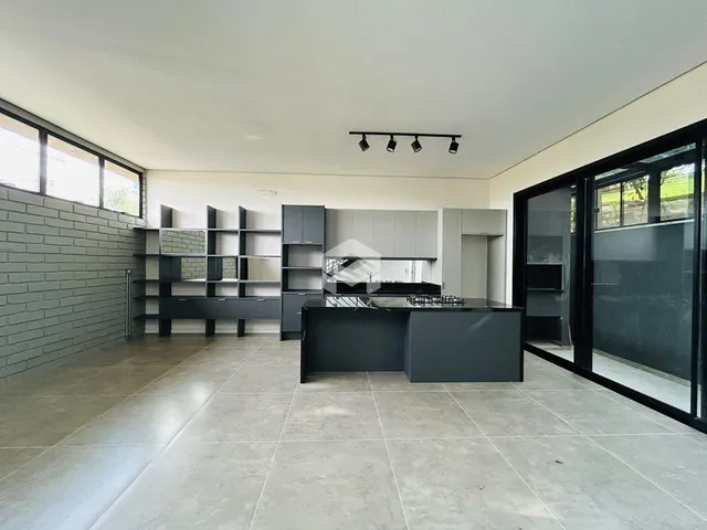 Vista da cozinha moderna com piso de cerâmica e grandes janelas.