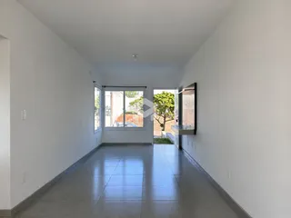 Hall de uma residência com paredes brancas e piso de cerâmica clara.