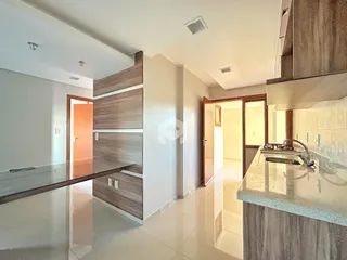 Vista de uma cozinha moderna com armários de madeira e piso claro.