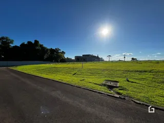 Campo verde com uma estrada no primeiro plano de uma propriedade em Lajeado.