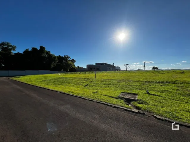 Campo verde com uma estrada no primeiro plano de uma propriedade em Lajeado.