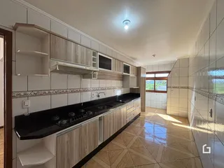Foto de uma cozinha com armários e piso de cerâmica em um imóvel no Brasil.