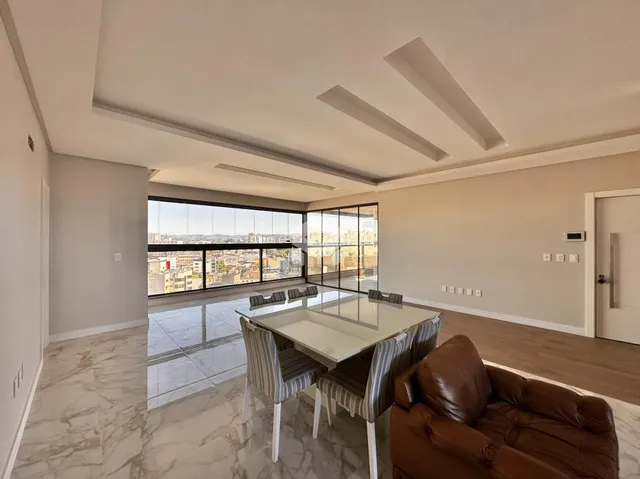 Sala de estar com grande janela oferecendo vista para a cidade.